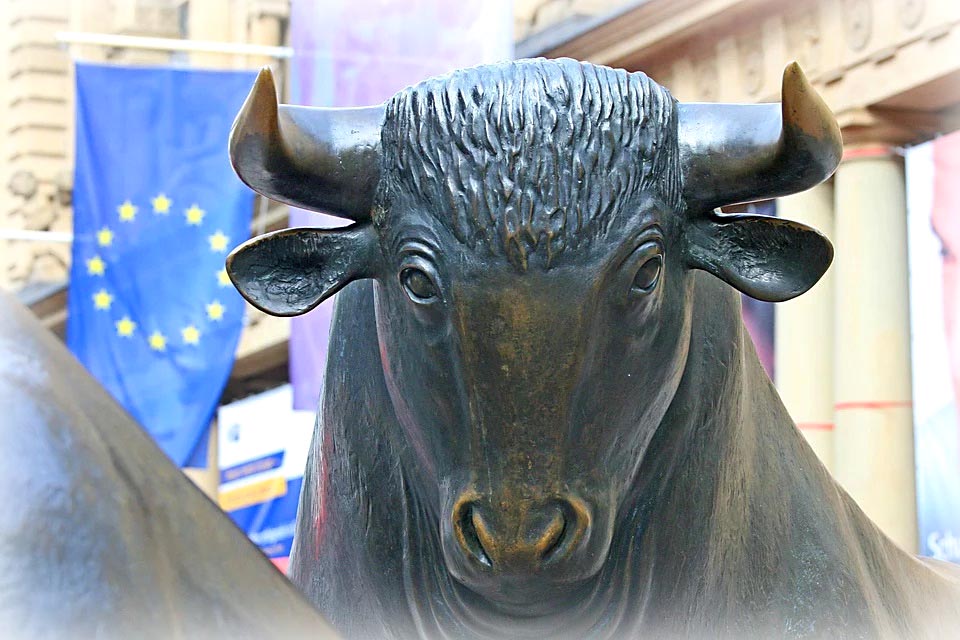 In Bronze glänzender Kopf eines Bullen oder Ochsen. Im Hintergrund erkennbar die blaue Europa-Flagge mit gelben Sternen.