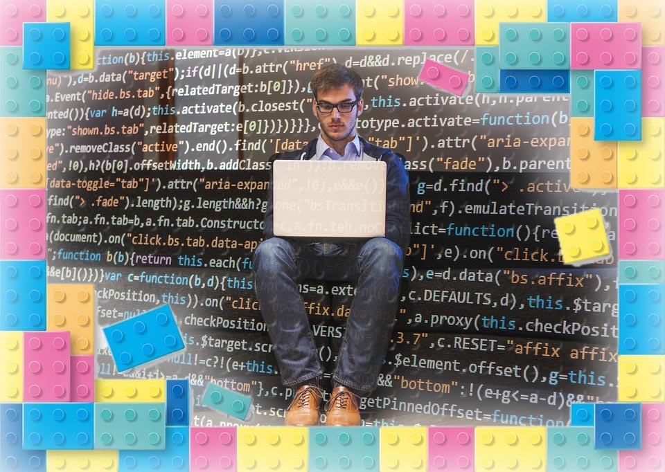 Programmierzeilen im Hintergrund, davor sitzt ein Mann mit Laptop auf den Knien. Das Bild ist umrahmt von bunten Legosteinen.