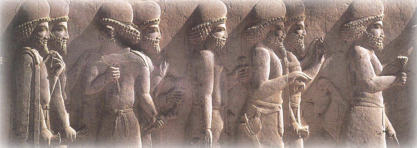 Ein uraltes, steinernes Wandrelief zeigt acht bärtige Männer, die Gegenstände in der Hand halten und einem Ziel entgegenstreben.