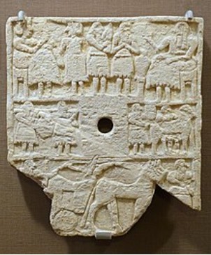 Mit Reliefs bestückte steinerne Weihplatte aus der Bronzezeit.
